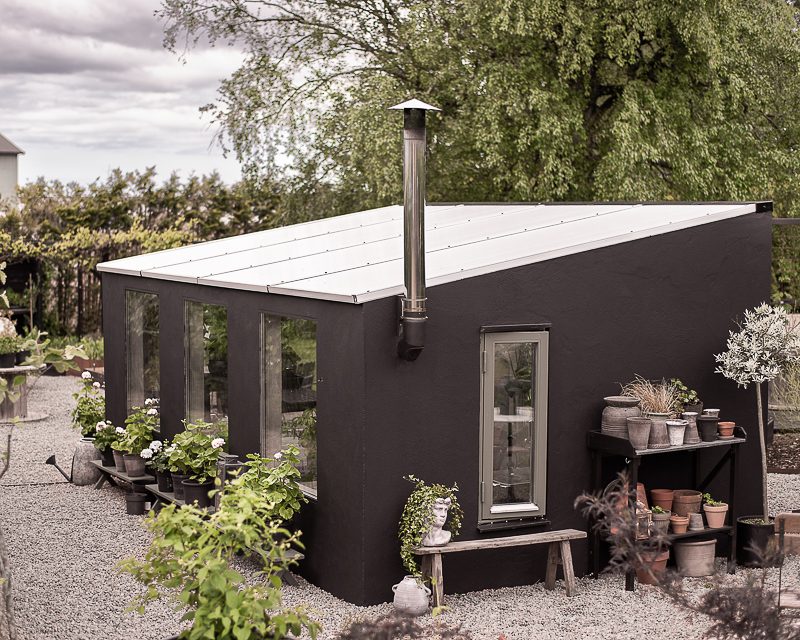 Ett litet växthus med kanalplasttak där tomaterna växer i ljus och värme